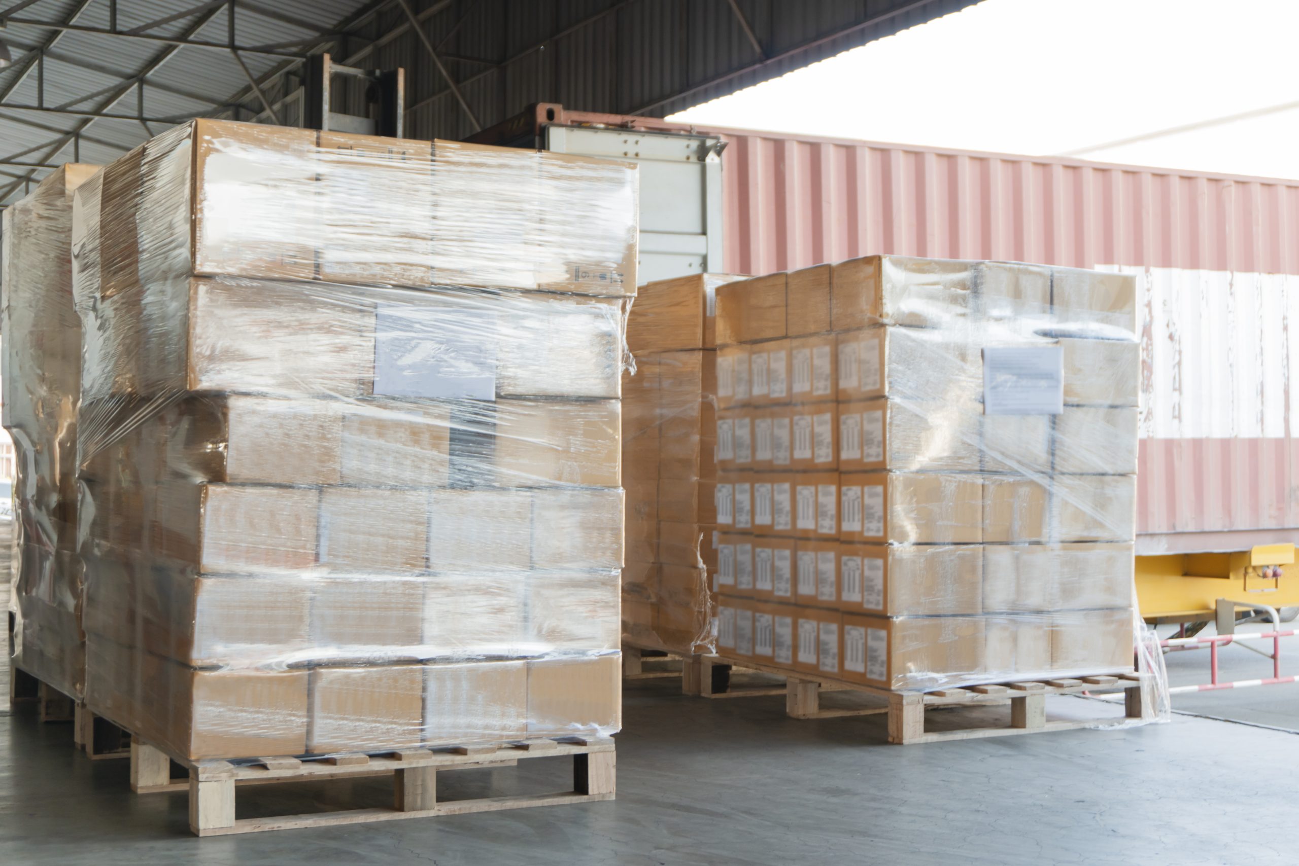 shipping metal components stacked boxes plastic wrapped, trucking dock station